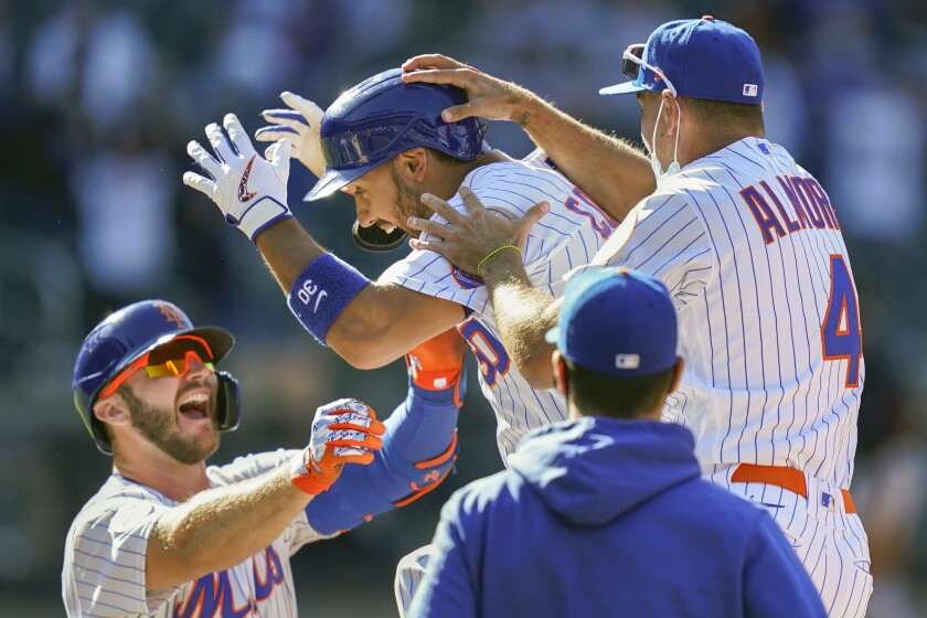 New York Mets' Michael Conforto (30) celebrates after being hit by a pitch and scoring the winning run on loaded bases during the ninth inning of a baseball game against the Miami Marlins, Thursday, April 8, 2021, in New York. (AP Photo/John Minchillo)