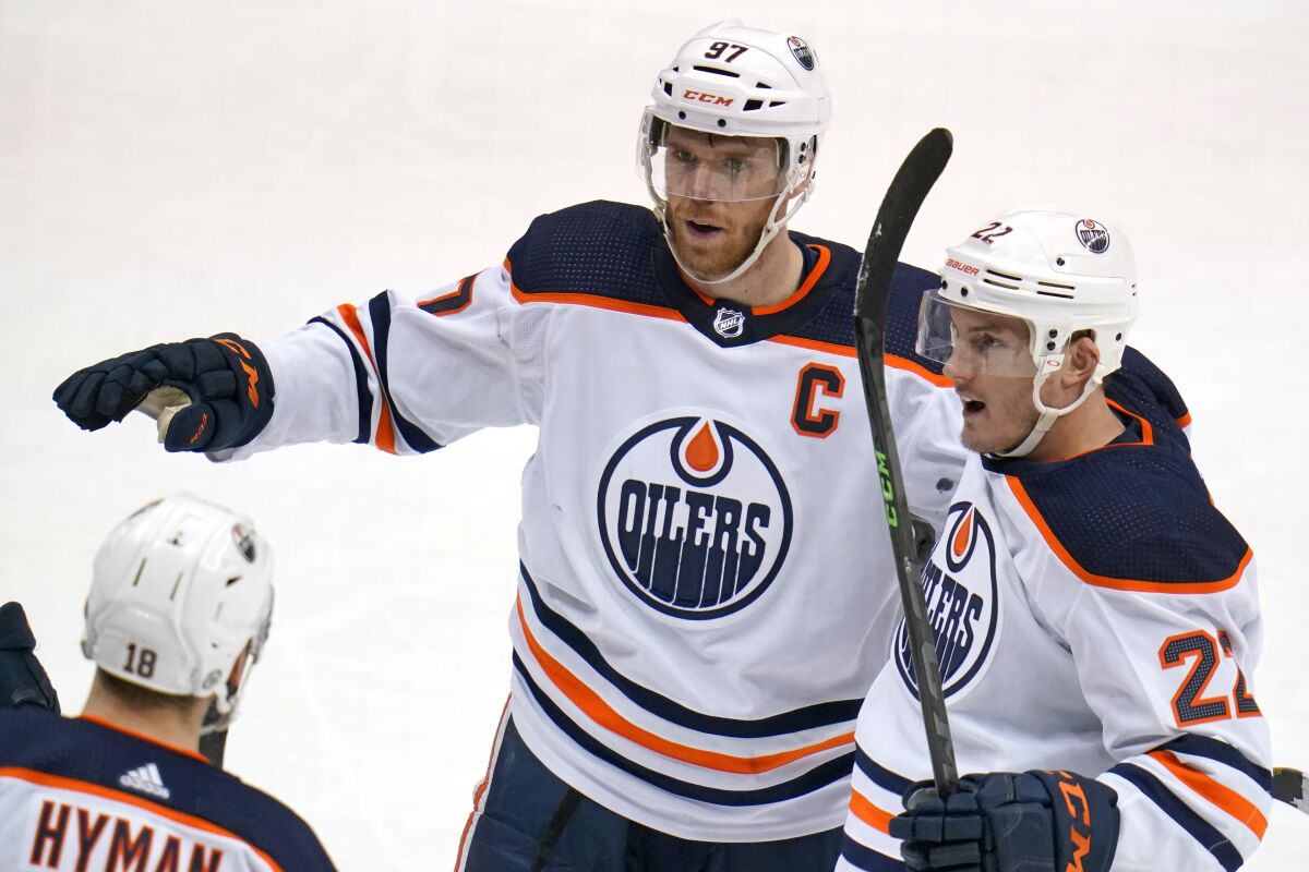 Edmonton Oilers' Connor McDavid (97) celebrates with Tyson Barrie (22) after scoring during the third period of the team's NHL hockey game against the Pittsburgh Penguins in Pittsburgh, Tuesday, April 26, 2022. The Oilers won 5-1. (AP Photo/Gene J. Puskar)