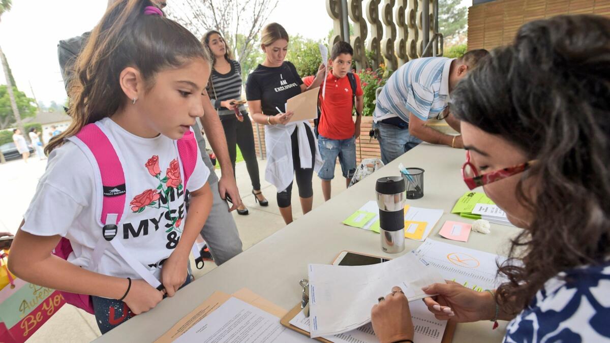 Fifth-grader Armine Arshakyan, left, checks in to find her classroom at Thomas Jefferson Elementary School on the Monday, Burbank's first day of school.