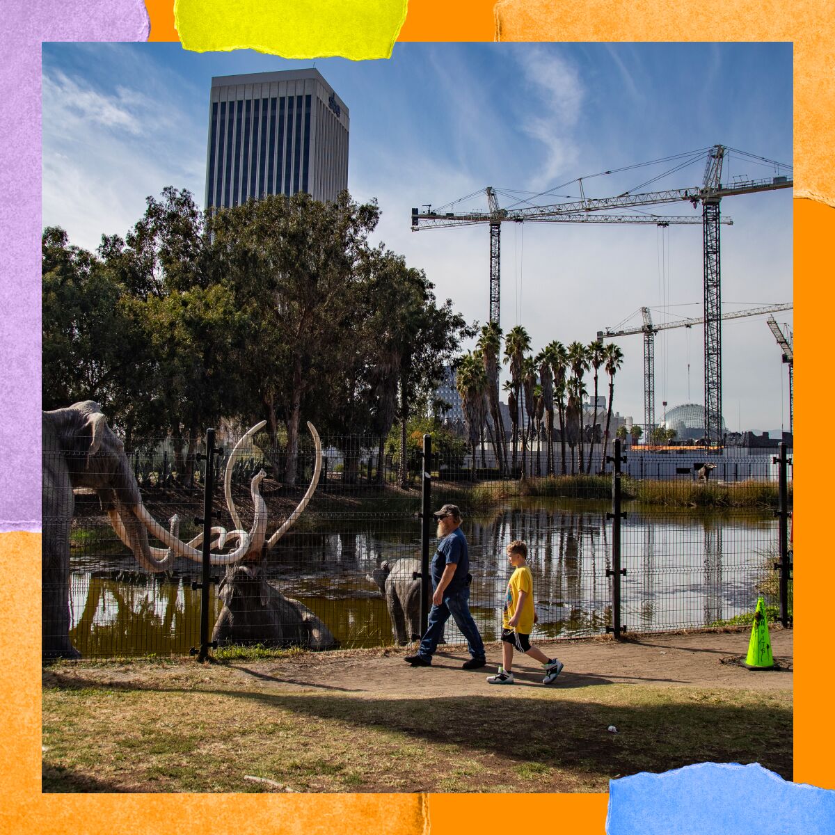People walk alongside a body of water with statues of woolly mammoths. In the background are construction cranes.