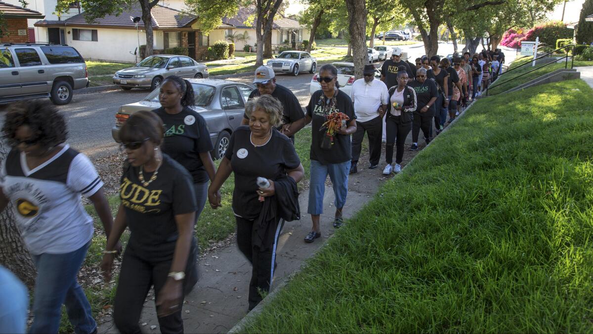 Community members join together for a prayer walk in remembrance of Jason Spears, 12, who was shot to death in March.