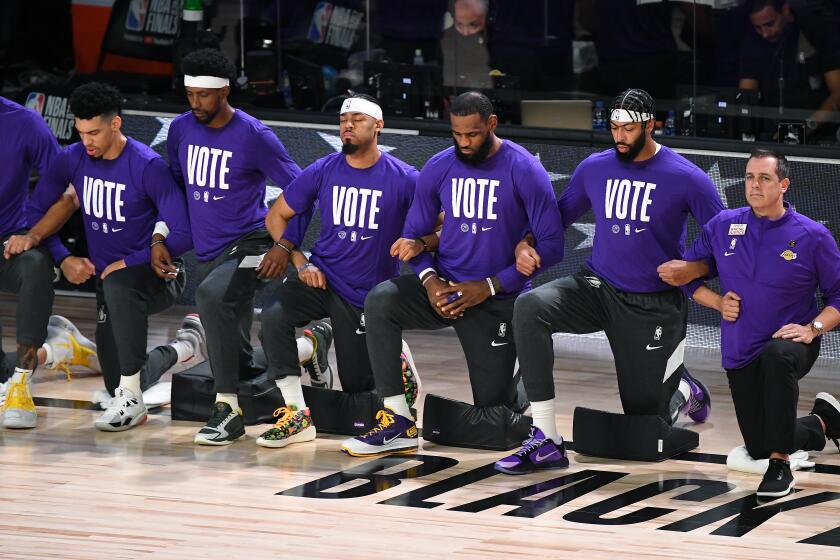 ORLANDO, FLORIDA SEPTEMBER 30, 2020-Lakers players kneel during the National Anthem before Game 1.