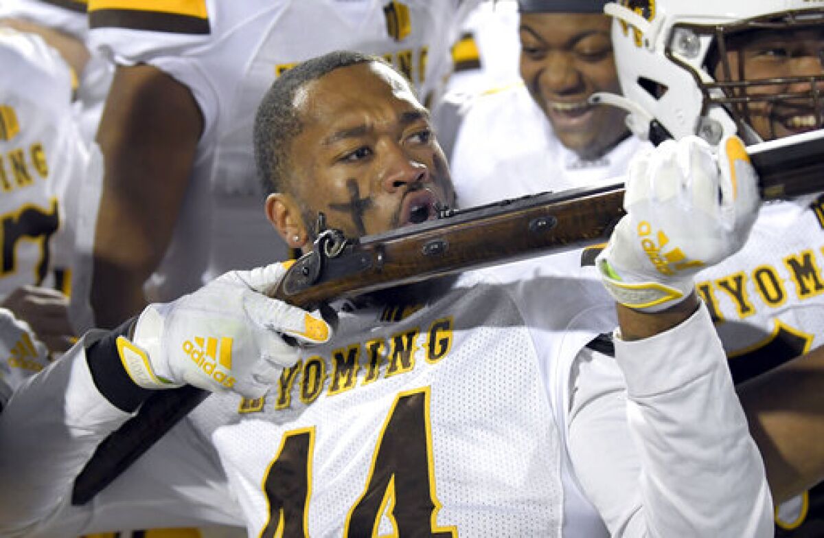 Wyoming defensive end Victor Jones celebrates with the Bridger Rifle trophy after defeating Utah State in an NCAA college football game on Saturday, Nov. 20, 2021, in Logan, Utah. (Eli Lucero/The Herald Journal via AP)
