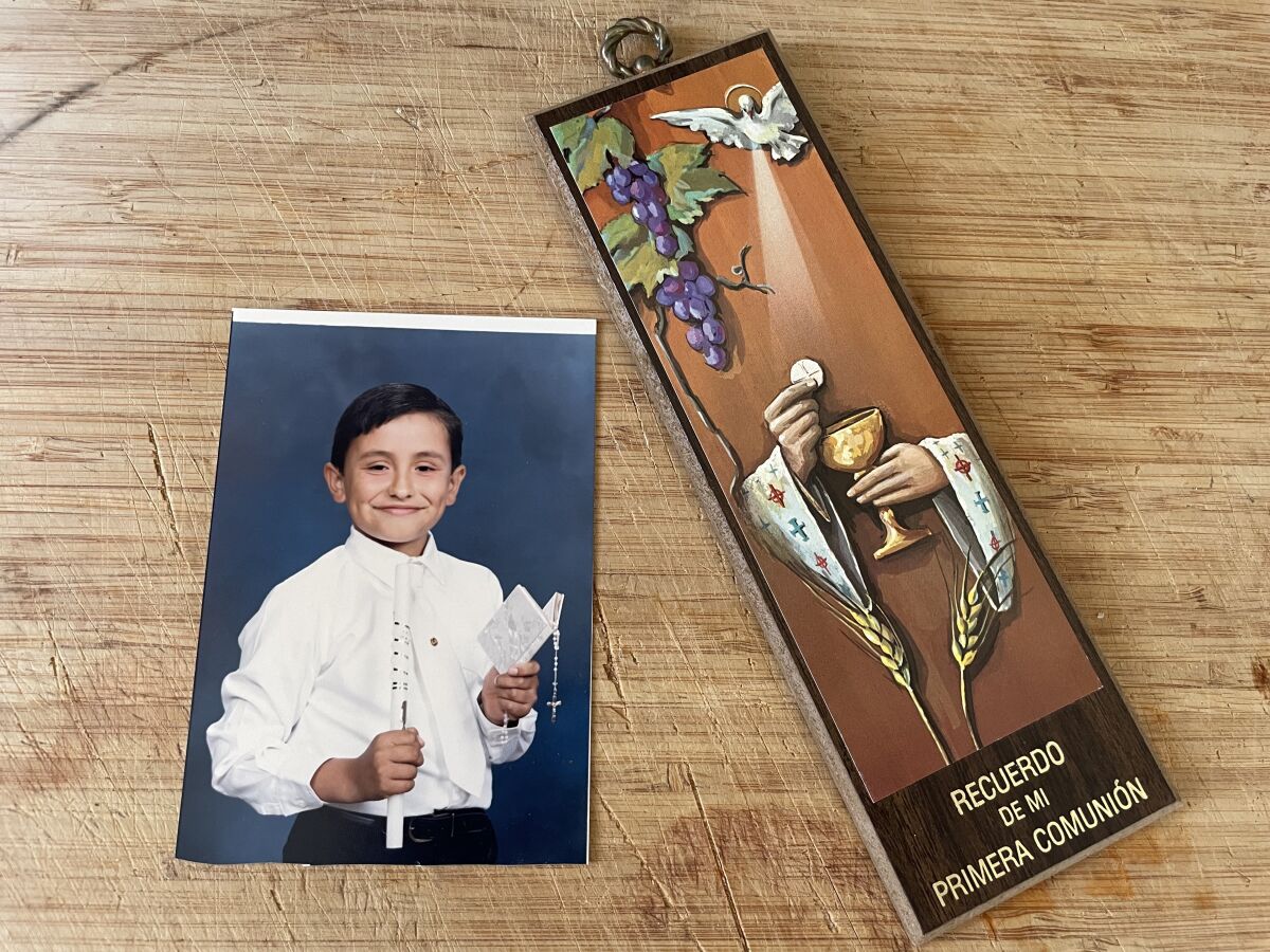 A photo of the author's First Communion, along with a souvenir from the ceremony