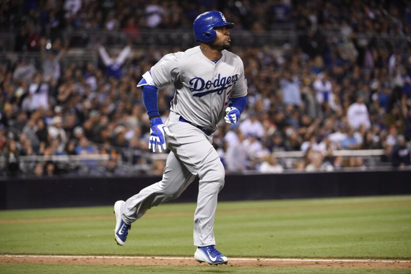 Dodgers outfielder Carl Crawford watches the ball's flight as he runs to first base in a game against the Padres in San Diego on April 24.