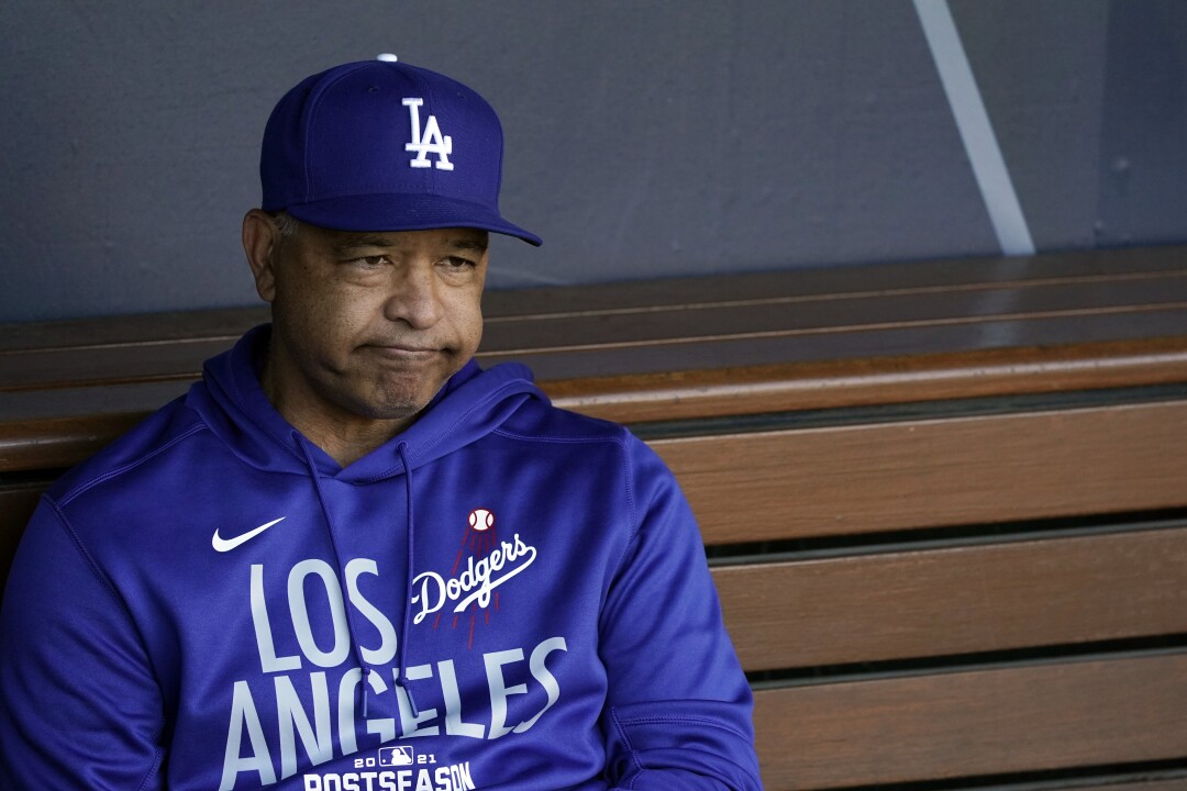 Dodgers manager Dave Roberts sits alone in the dugout.
