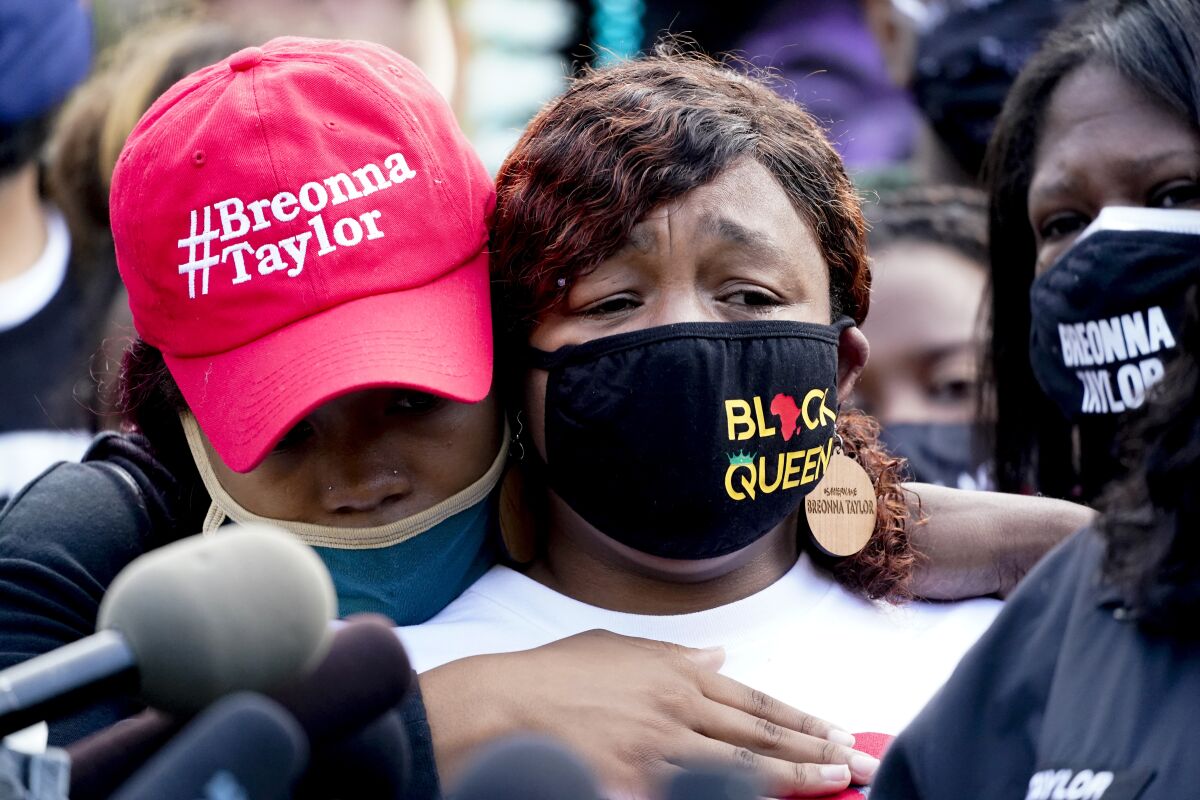 Tamika Palmer, right, the mother of Breonna Taylor, listens to a news conference Friday in downtown Louisville, Ky.