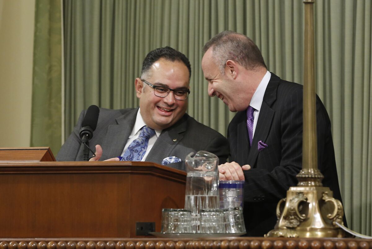Assembly Speaker John Perez (D-Los Angeles), left, and Senate President Pro Tem Darrell Steinberg (D-Sacramento) talk during the Assembly session last September. Perez said he will step down from the speaker post after next year's budget is passed.
