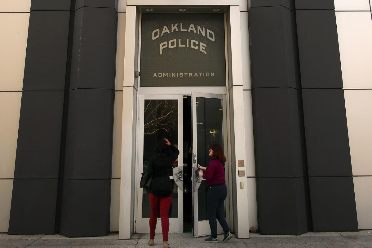 People stand outside the entrance to the Oakland police headquarters.