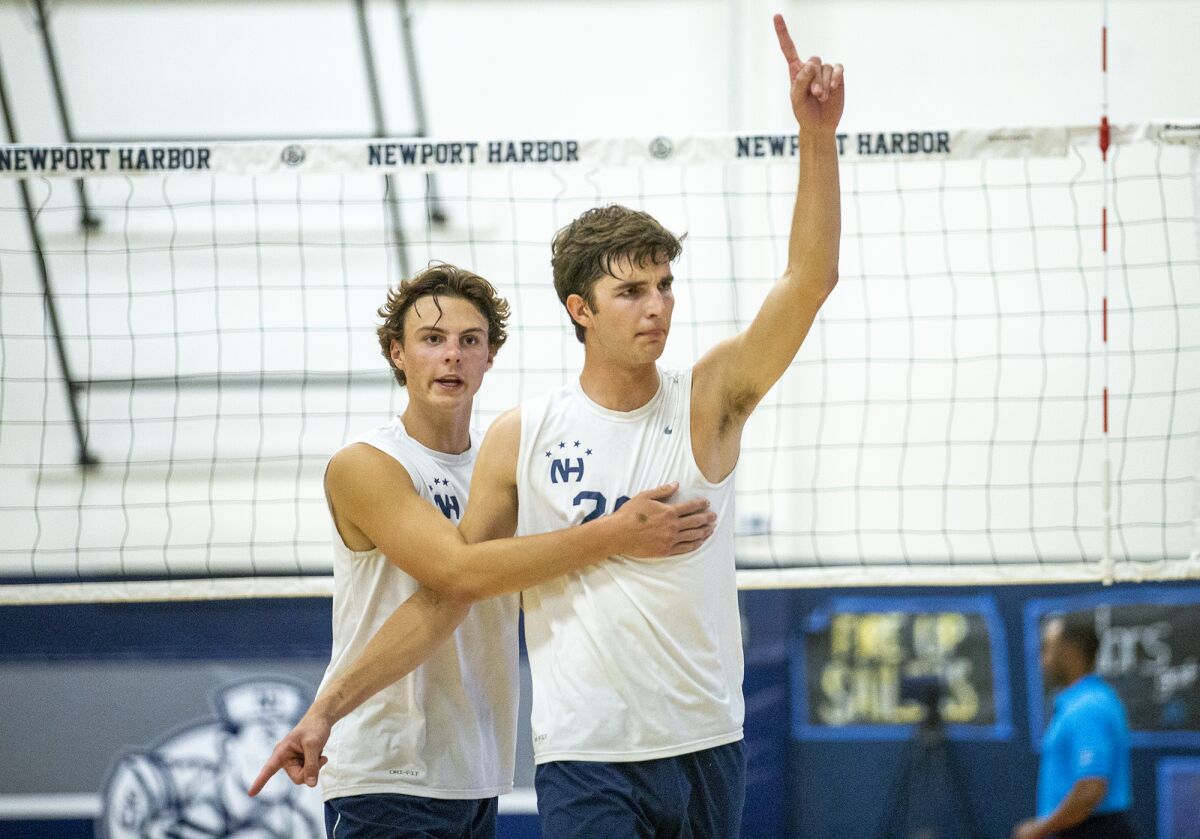 Newport Harbor's Riggs Guy, left, celebrates with James Eadie after he blocks a Los Alamitos hitter on Tuesday.