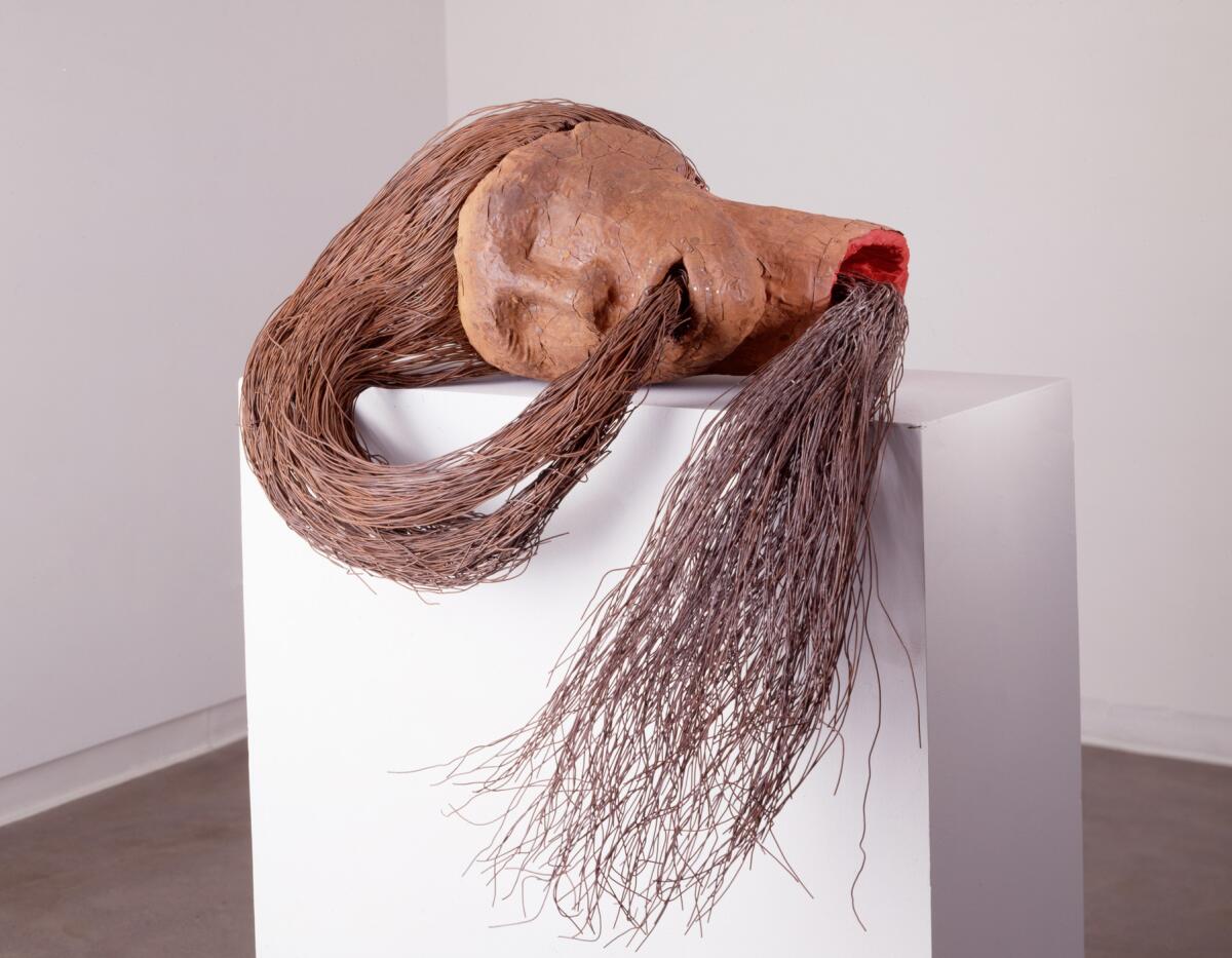 Sculpture of a face swallowing its own long hair
