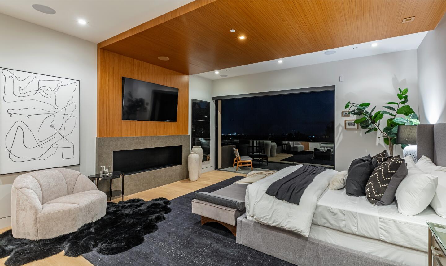 The bedroom has furniture, wood floor, built-in TV and a big window.