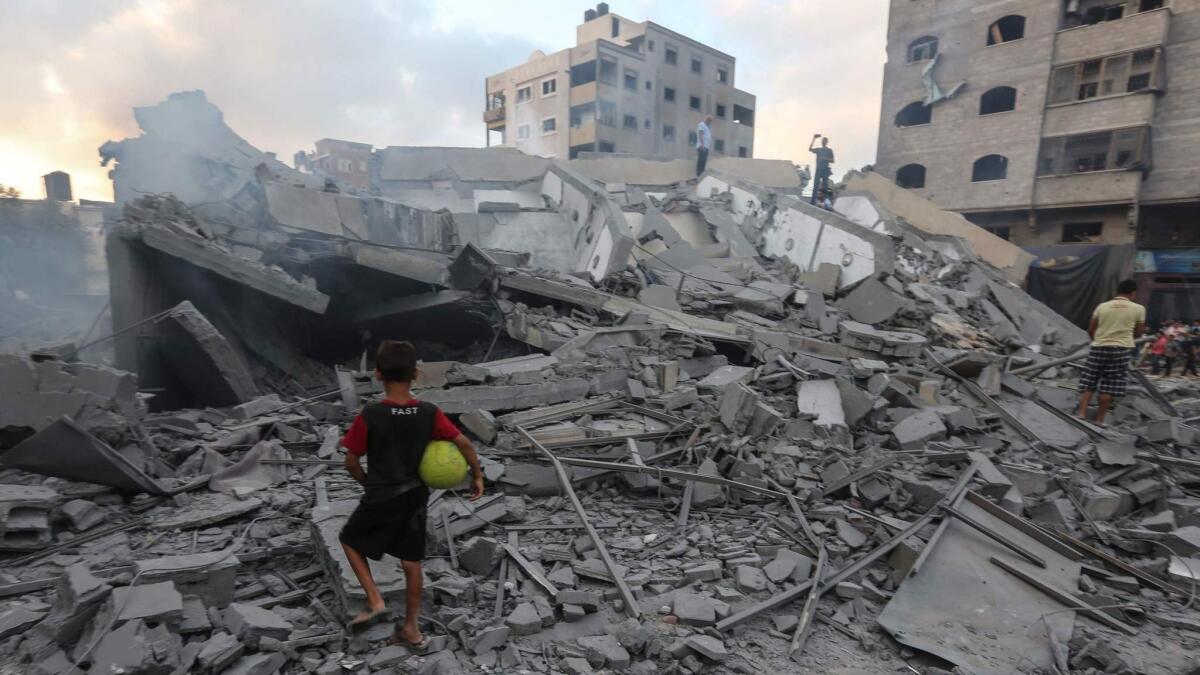 A boy looks at the rubble of a building in Gaza City after an Israeli airstrike on Aug. 9.