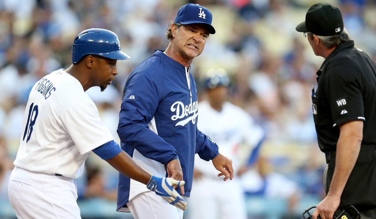 Dodgers Manager Don Mattingly and Chone Figgins (18) argue a batter's interference call with home plate umpire Paul Nauert during the first inning of a game against the Pirates on Friday at Dodger Stadium.