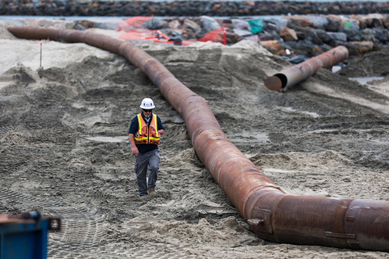 A long, wide metal tube along the sand