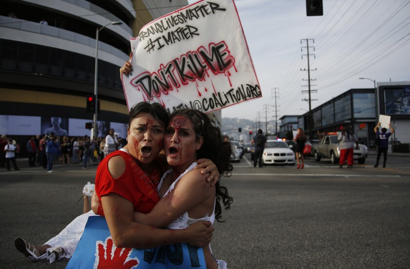 Jennicet Gutierrez, left, and Johanna Saavedra take part in the March 20 "Spring into Love" rally in Los Angeles to protest violence against transgender people.