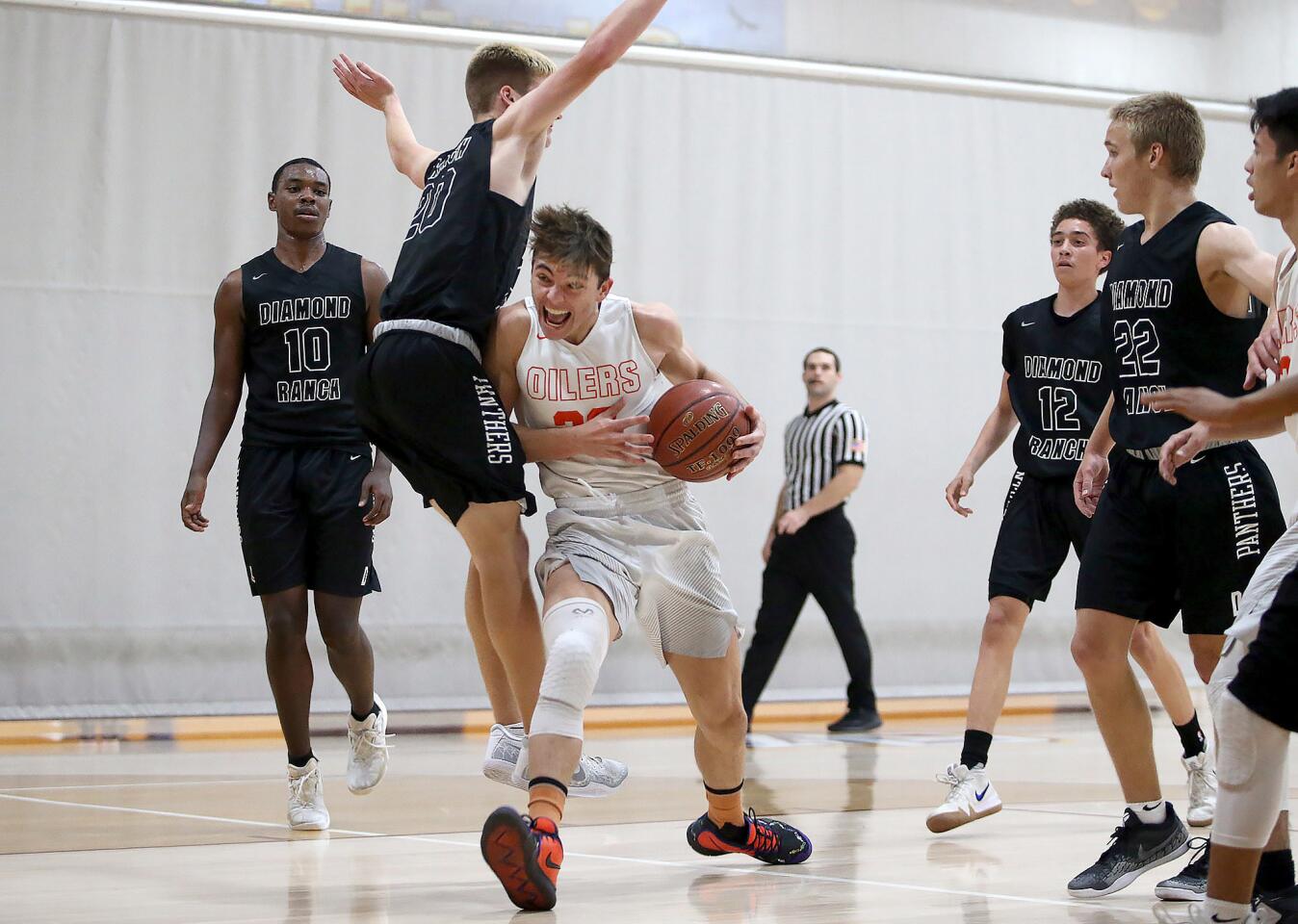 John Stenlund of Huntington Beach High drives to the basket as Pomona Diamond Ranch's Connor Parker plays tight defense in a Jim Harris Classic pool-play game at Ocean View High on Tuesday.