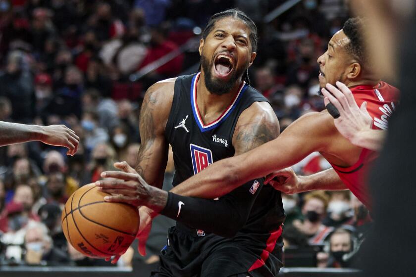 The Clippers' Paul George, left, is fouled by the Trail Blazers' CJ McCollum during the second half Oct. 29, 2021.
