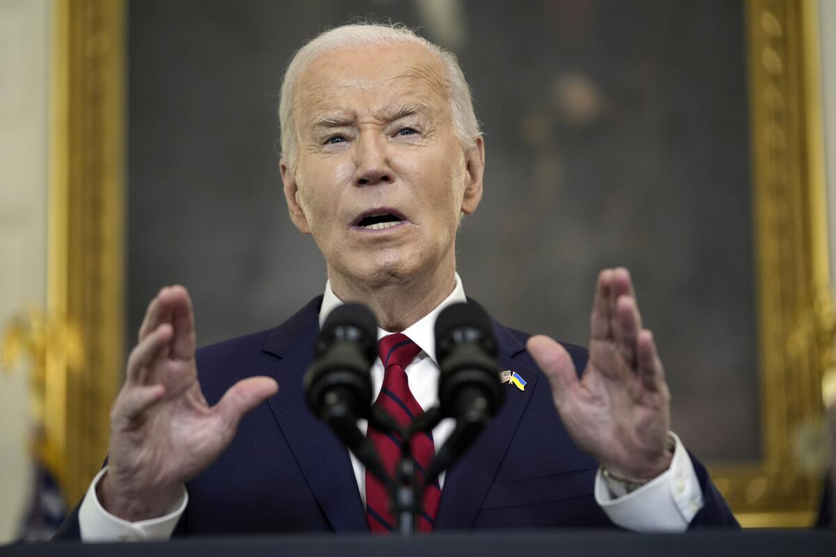 President Biden gestures with both hands as he speaks in the White House.