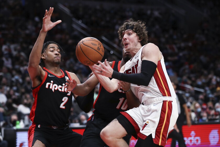 Miami Heat guard Kyle Guy passes the ball away from Portland Trail Blazers forward Trendon Watford (2) and guard Dennis Smith Jr. (10) during the second half of an NBA basketball game in Portland, Ore., Wednesday, Jan. 5, 2022. (AP Photo/Amanda Loman)