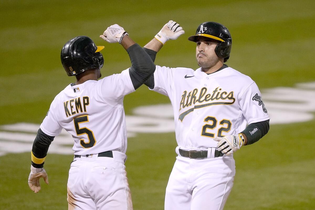 Oakland Athletics' Ramon Laureano (22) gets a forearm-bash with his teammates Tony Kemp (5) after hitting a two-run home run against the Toronto Blue Jays during the fifth inning of a baseball game in Oakland, Calif., on Monday, May 3, 2021. (AP Photo/Tony Avelar)
