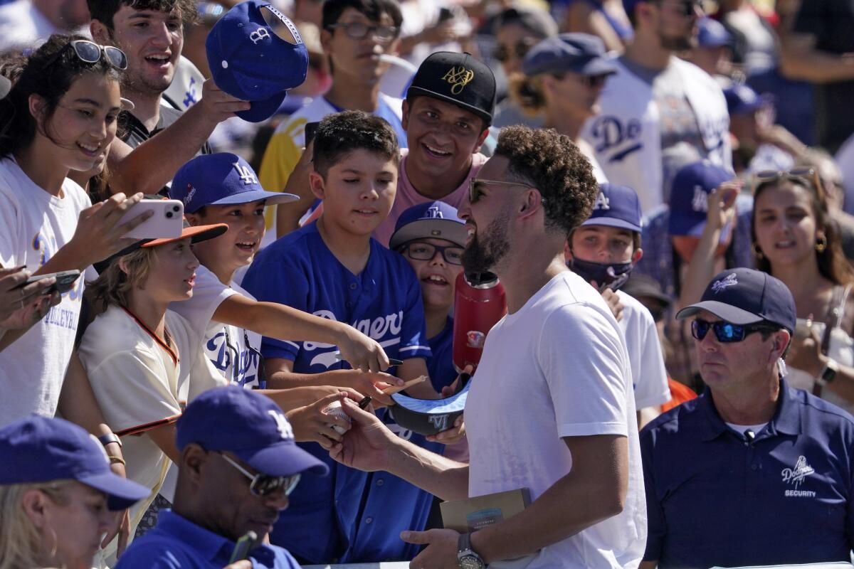 Golden State Warriors star Klay Thompson, whose brother Trayce Thompson plays on the Dodgers, signs autographs.