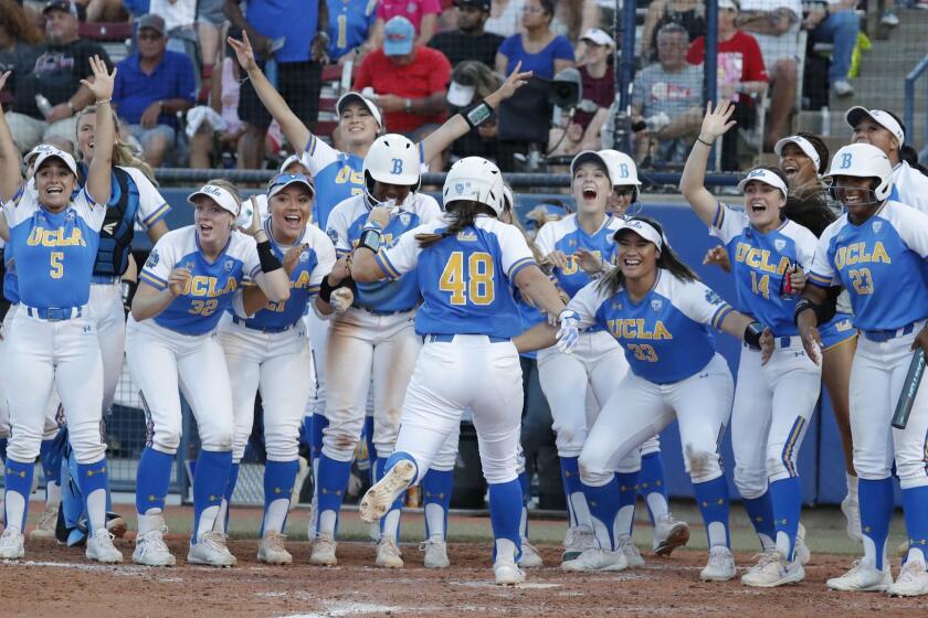 UCLA celebrates as Bubba Nickles (48) comes home after a home run against Oklahoma in the sixth inning of the first game of the best-of-three championship series in the NCAA softball Women's College World Series in Oklahoma City, Monday, June 3, 2019. (AP Photo/Alonzo Adams)
