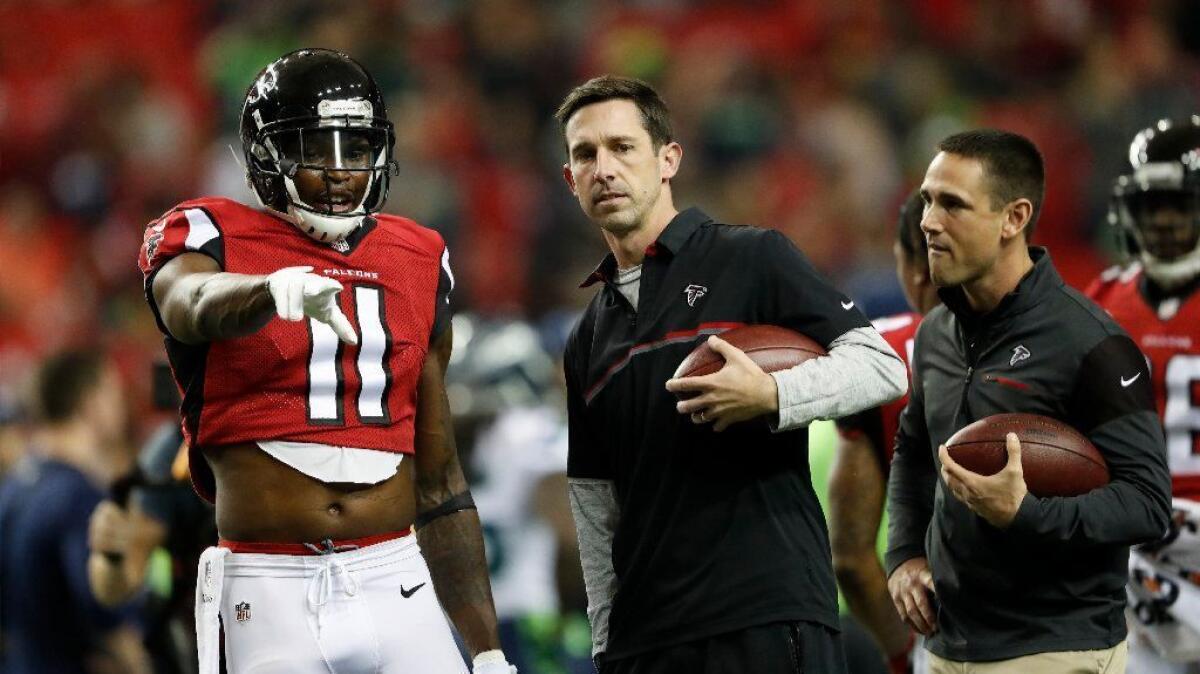 Atlanta Falcons offensive coordinator Kyle Shanahan talks with receiver Julio Jones before an NFL playoff game against the Seahawks on Jan. 14.