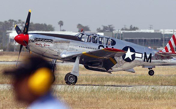 Violet Cowden, 89, one of the military's first female aviators during World War II, is seated in the rear of the world's only dual-control P-51C Mustang as it arrives from San Diego at Long Beach Airport for a vintage aircraft show. Thousands of P-51s were built in Long Beach.