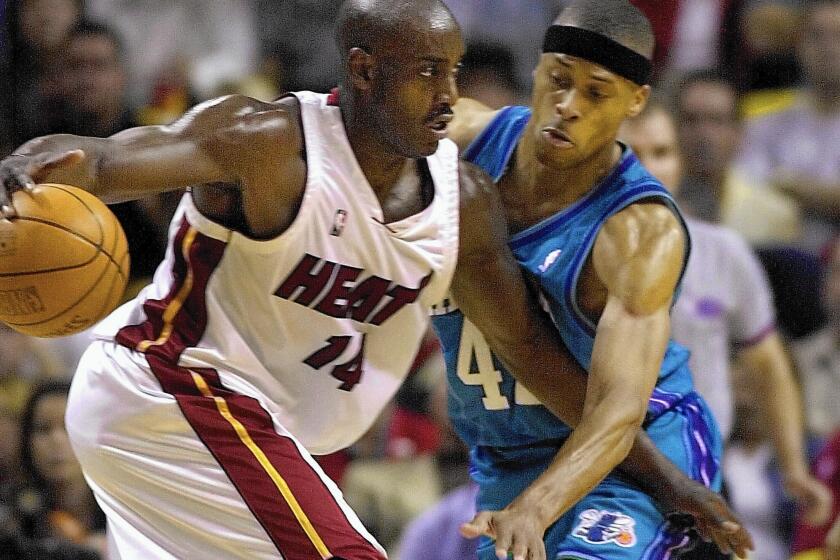 Miami's Anthony Mason, left, drives against Charlotte's P.J. Brown in an NBA game in 2001. Mason, a rugged power forward who was a defensive force throughout his career, has died at the age of 48.