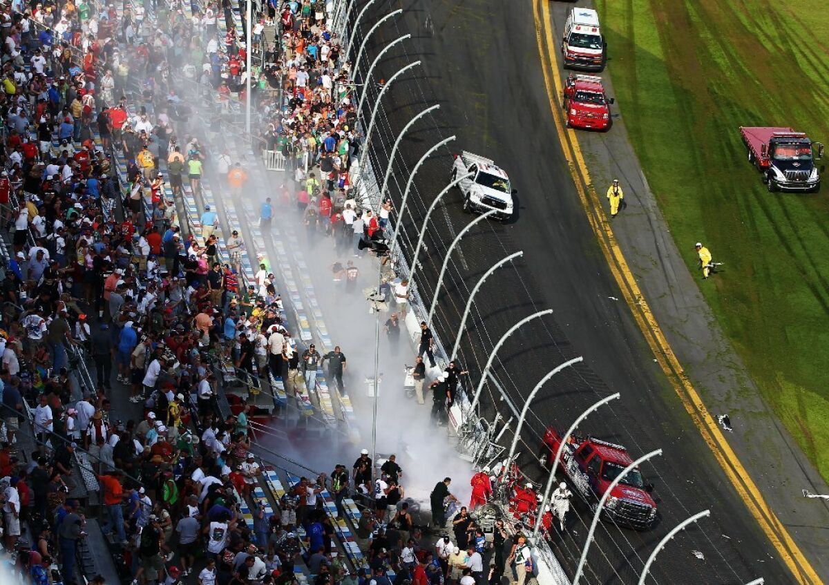 Emergency workers tend to fans injured by flying debris from a crash in a NASCAR Nationwide Series race at Daytona International Speedway on Saturday.