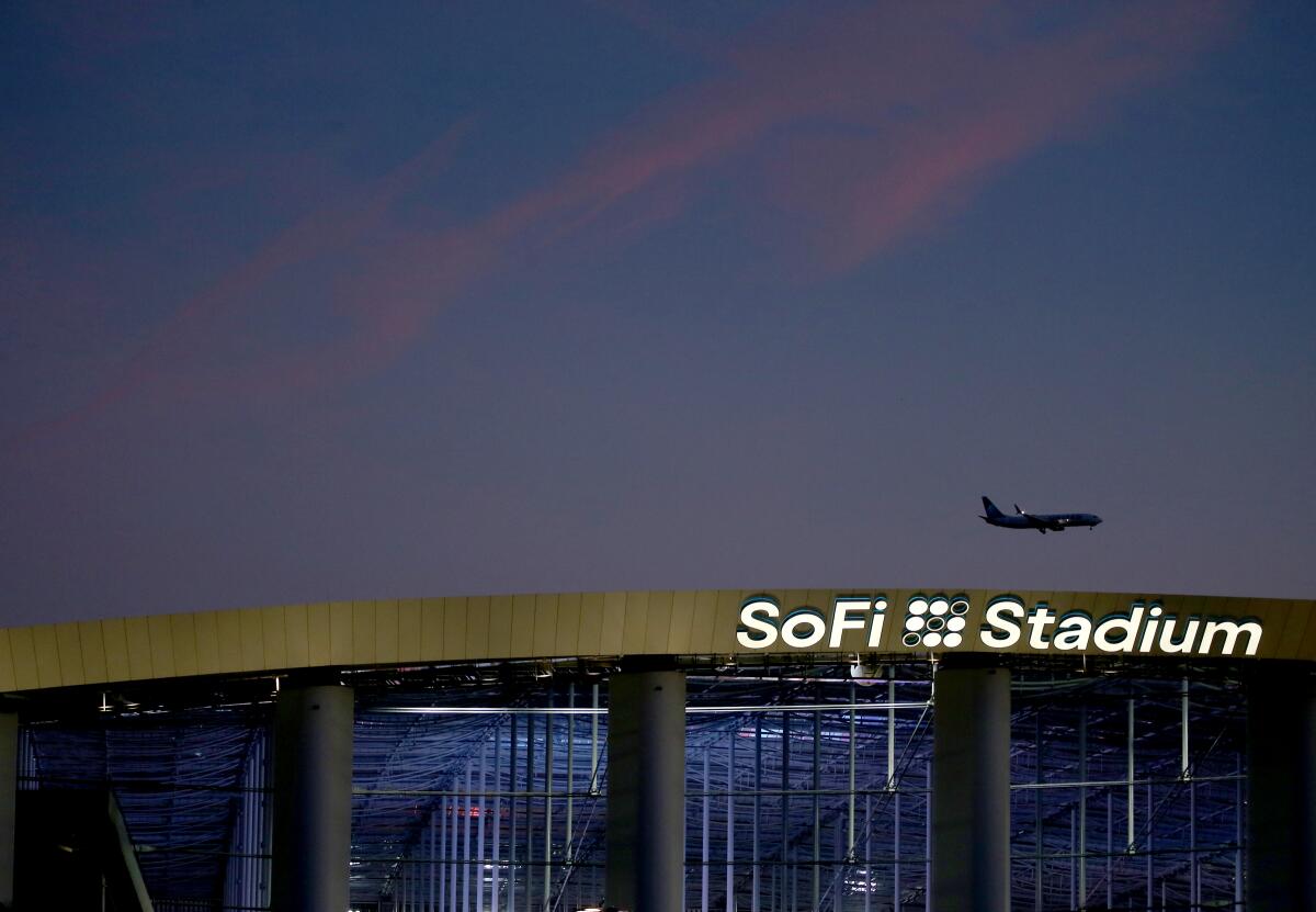A plane heading to Los Angeles International Airport flies over SoFi Stadium in Inglewood.