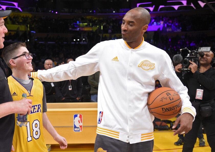 Los Angeles Lakers forward Kobe Bryant talks with Make-A-Wish recipient Yitzi Tiechman before a game against the Charlotte Hornets on Sunday at Staples Center. The Lakers signed the teenager to a one-day contract before the game.