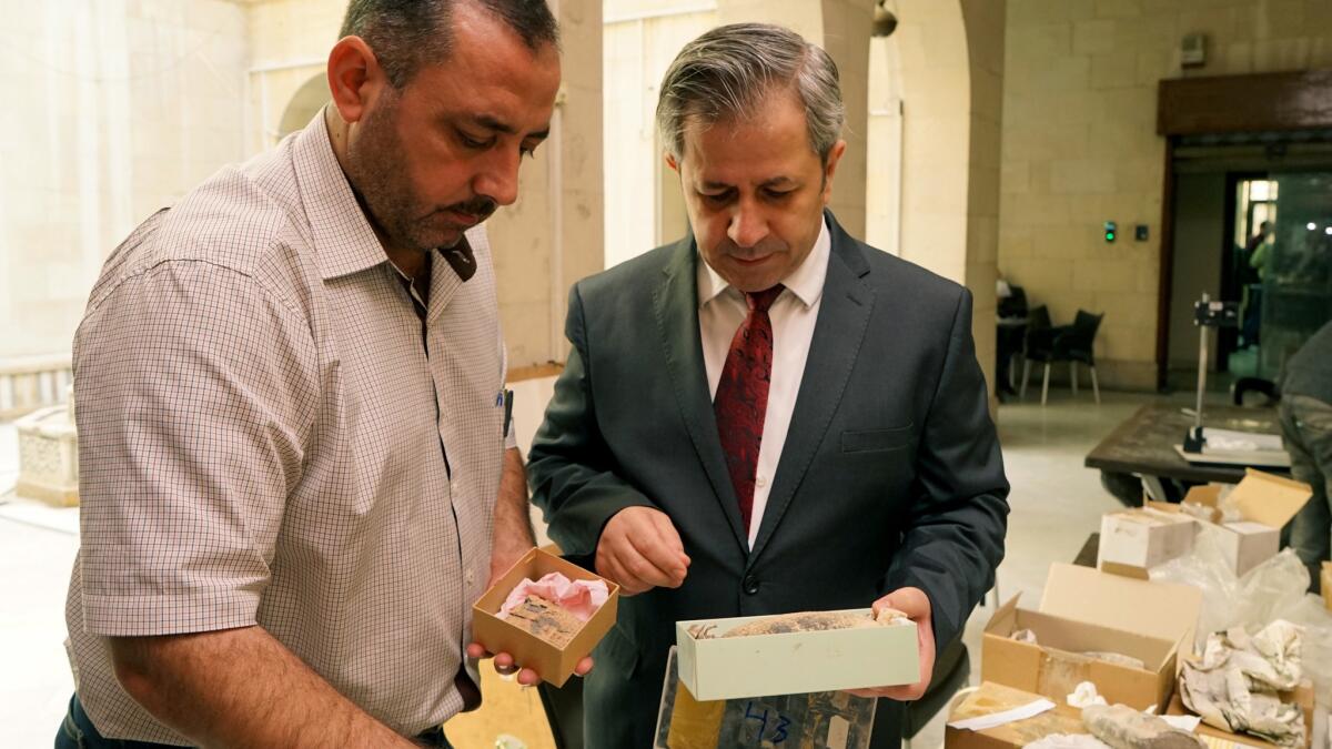 Maamoun Abdulkarim, right, Syria’s director of antiquities, at the National Museum in Damascus with Mohammed Asaad, son of Khaled Asaad, the former curator of Palmyra who was beheaded by extremists in 2015.