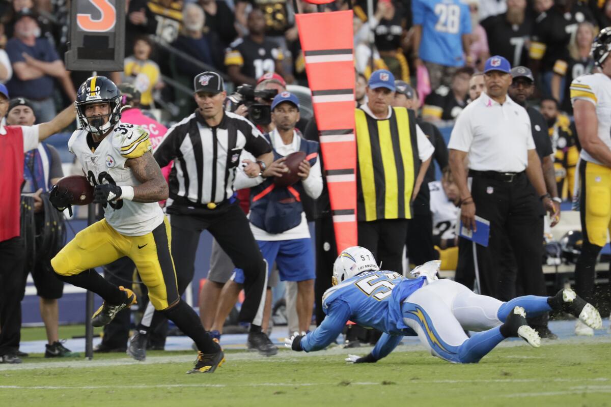 Pittsburgh Steelers running back James Conner, left, sprints past Chargers outside linebacker Jatavis Brown for a touchdown during the second quarter of the Chargers' 24-17 loss Sunday.