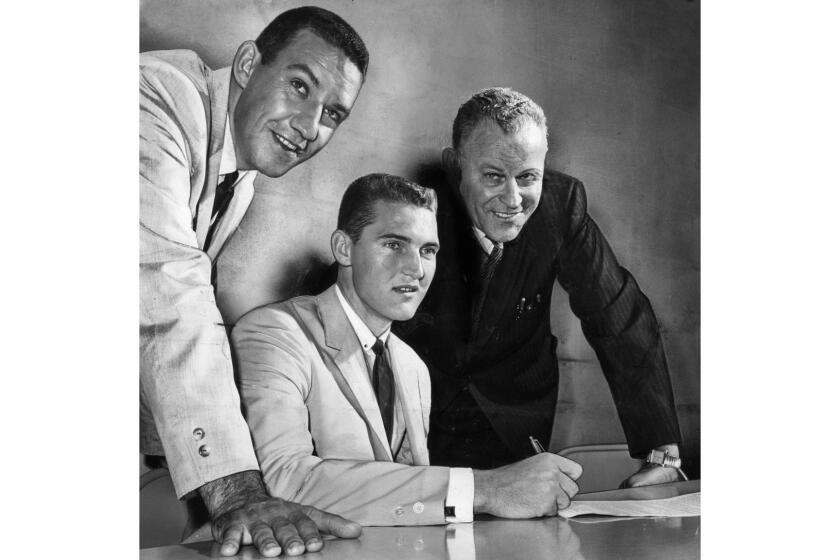 Sept. 20, 1960: Jerry West, an All-American at West Virginia and captain of the gold-medal-winning U.S. Olympic basketball team, signs a two-year contract with the Los Angeles Lakers. Looking on are Lakers coach Fred Schaus, left, and general manager Lou Mohs.