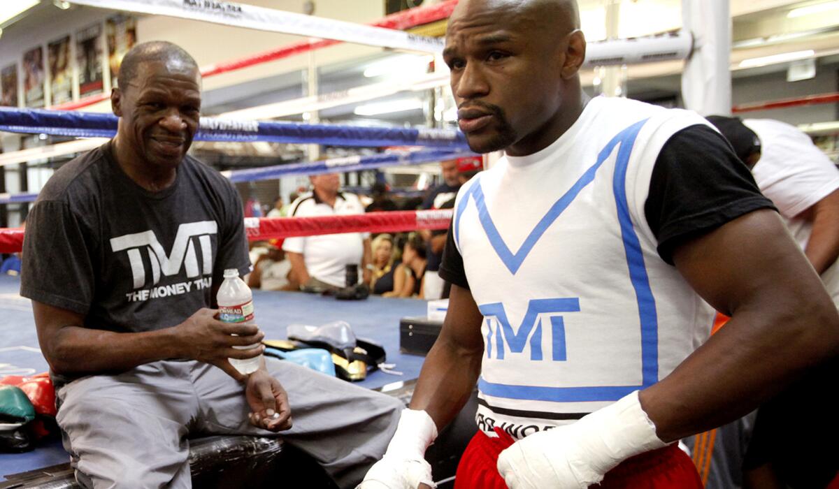 Floyd Mayweather, Sr., left, keeps a watchful eye on his son Floyd Mayweather, Jr. during a training session on Aug. 22, 2013.