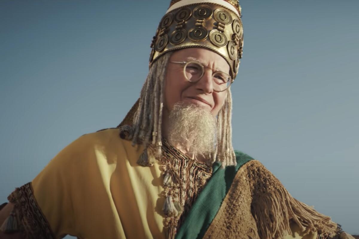 A man in glasses and an ancient-style toga and hat.