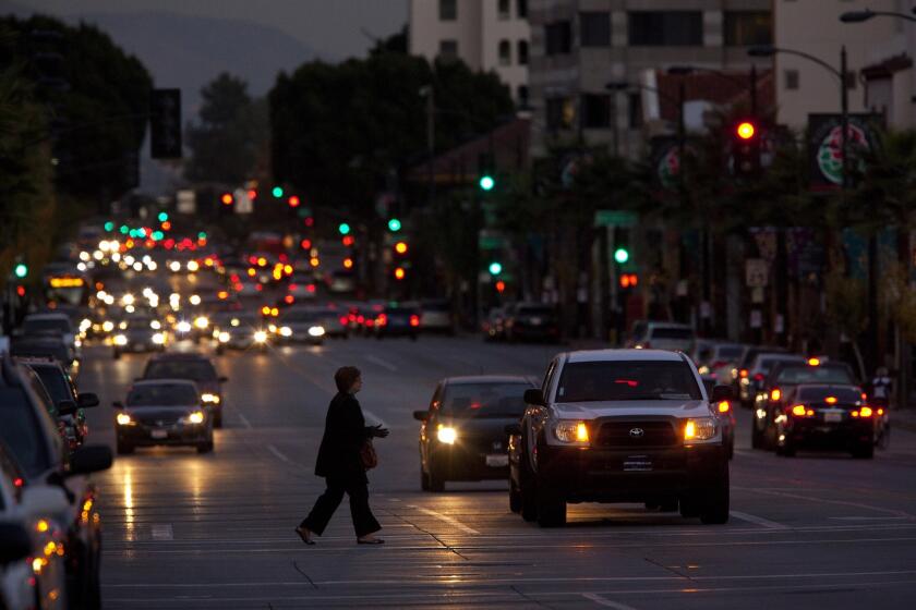 A pedestrian makes her way across a busy Colorado Boulevard at dusk. Nowhere is the chance to remake Colorado in Pasadena more pronounced than in the once-sleepy Playhouse District east of Old Pasadena.