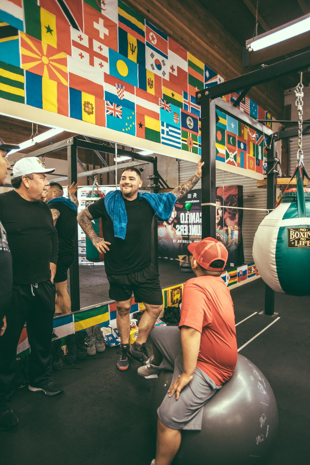 Andy Ruiz Jr. talks inside a boxing gym while his son AJ watches