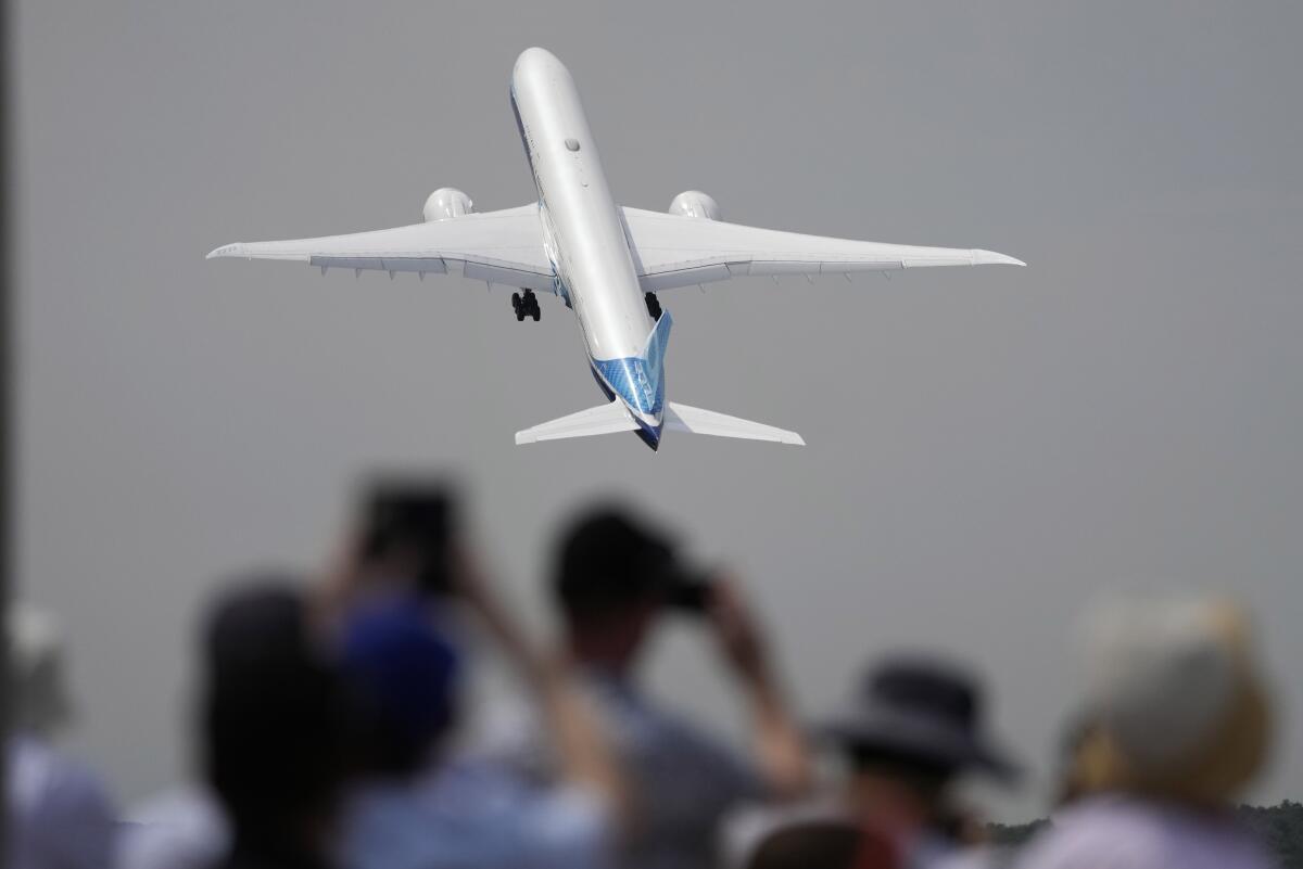 A Boing 777X plane takes off at the Farnborough air show in England