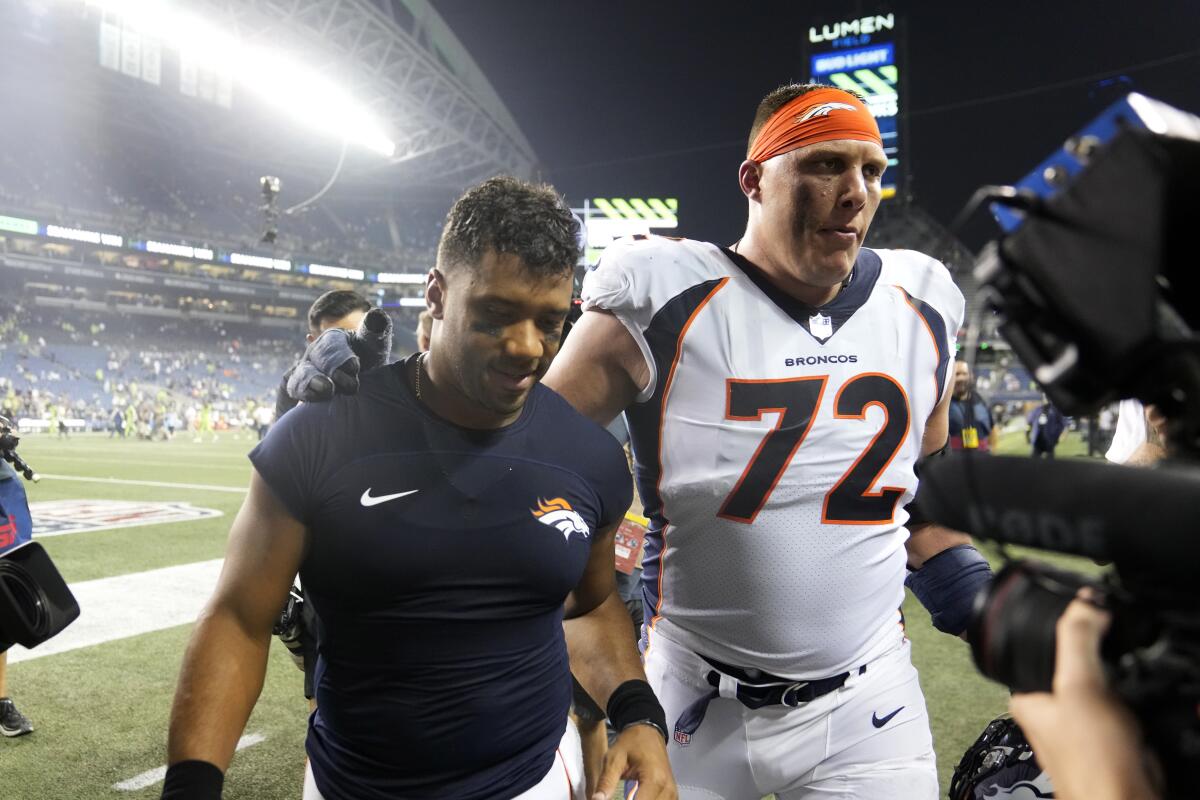 Denver Broncos quarterback Russell Wilson, left, walks off the field with offensive tackle Garett Bolles (72) after an NFL football game against the Seattle Seahawks, Monday, Sept. 12, 2022, in Seattle. The Seahawks won 17-16. (AP Photo/Stephen Brashear)