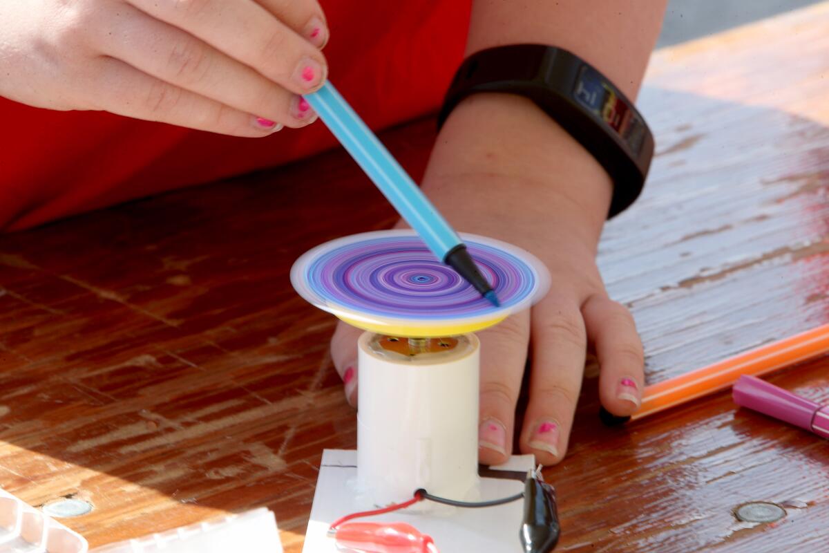 A student creates circular art with a marker as the solar unit spins around. The activity took place at the annual Glendale Water & Power Utility Day at the Utility Operations Center in Glendale on Thursday.