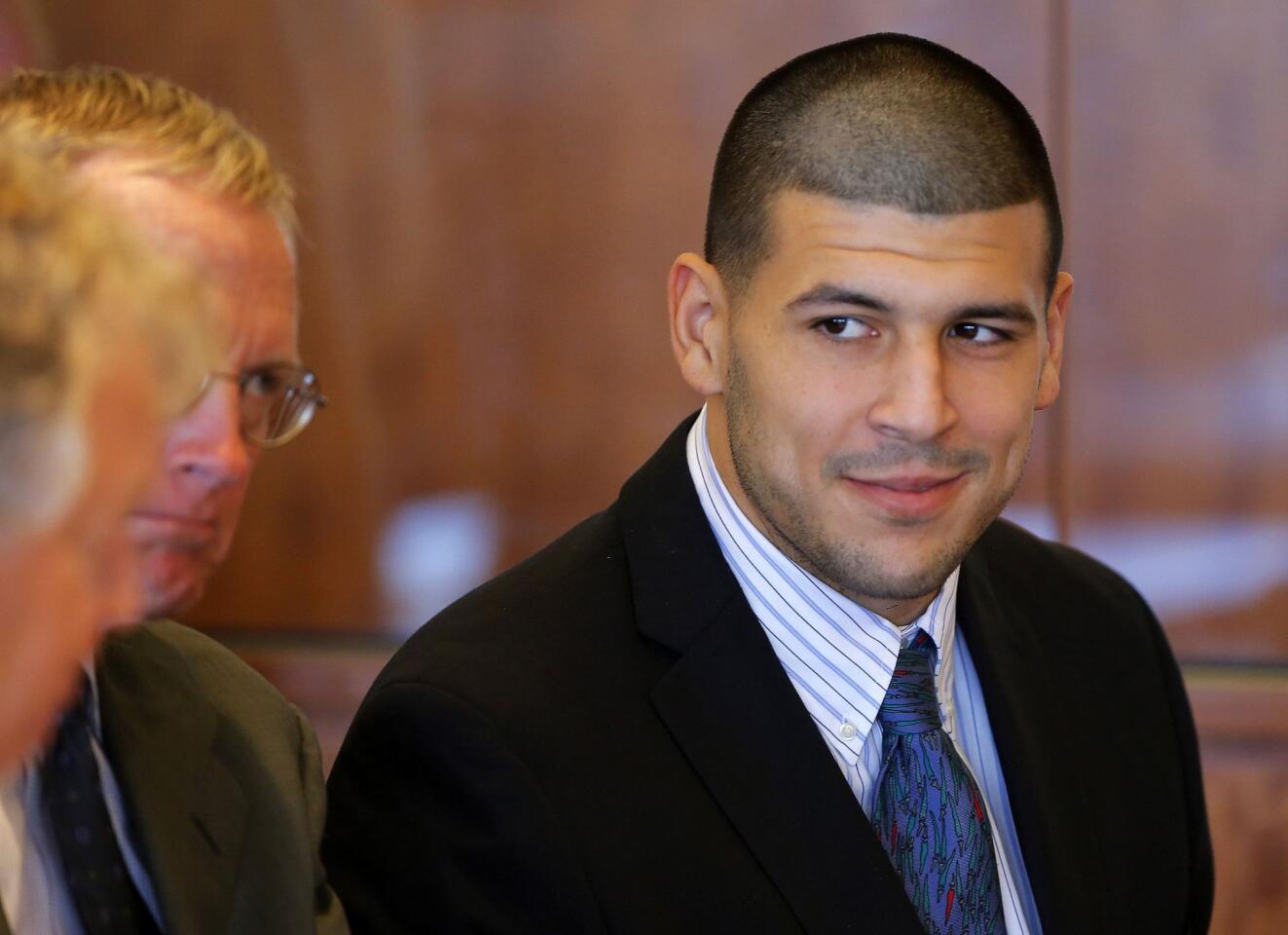 Aaron Hernandez, former player for the NFL's New England Patriots football team, listens to his attorneys during a court appearance at the Bristol County Superior Court in Fall River, Massachusetts October 9, 2013, in connection with the death of semi-pro football player Odin Lloyd in June. Hernandez, who was a rising star in the NFL before his arrest and release by the Patriots, has pleaded not guilty. REUTERS/Brian Snyder (UNITED STATES - Tags: CRIME LAW SPORT FOOTBALL) ORG XMIT: BKS02