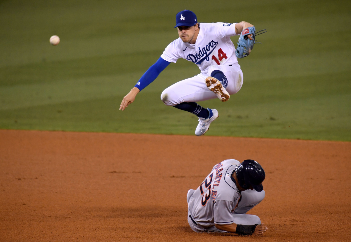 Dodgers second baseman Kiké Hernández jumps over Houston baserunner Michael Brantley.