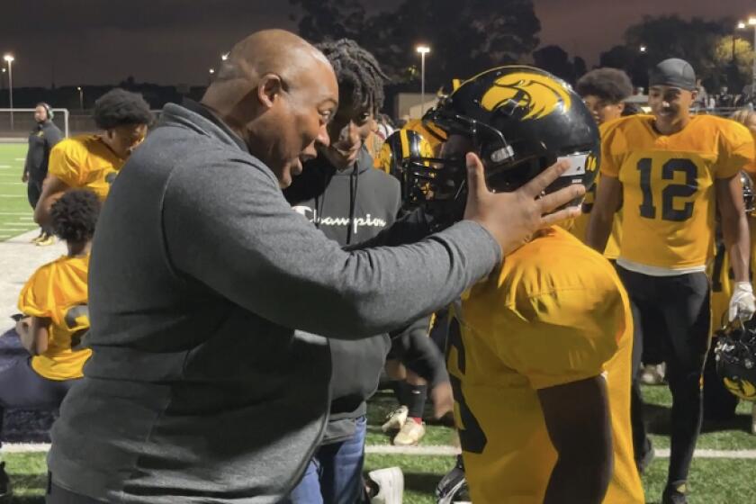 King/Drew coach Joe Torres congratulates running back Elijah Mosley after a touchdown.