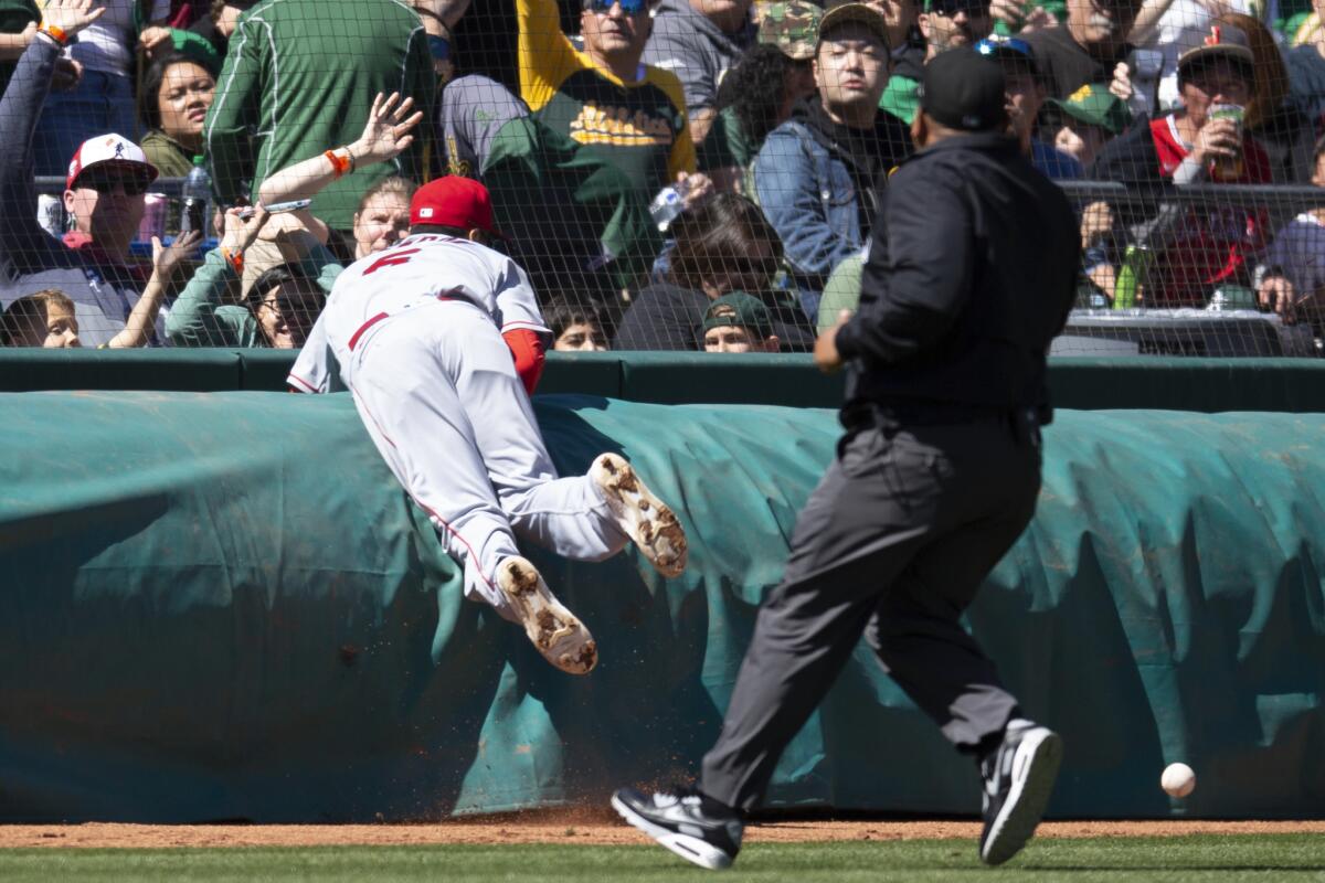 Angels third baseman Anthony Rendon crashes into a tarp while pursuing a foul pop in the fourth inning.