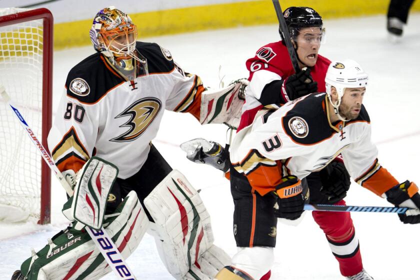 Senators right wing Mark Stone clears Ducks defenseman Clayton Stoner from in front of goalie Ilya Bryzgalov before scoring in the first period Friday night in Ottawa.