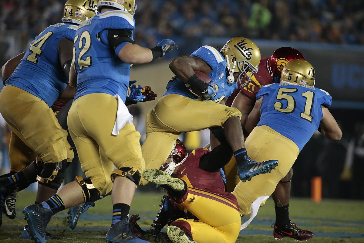 UCLA running back Paul Perkins leaps over a USC defender at the Rose Bowl in November.