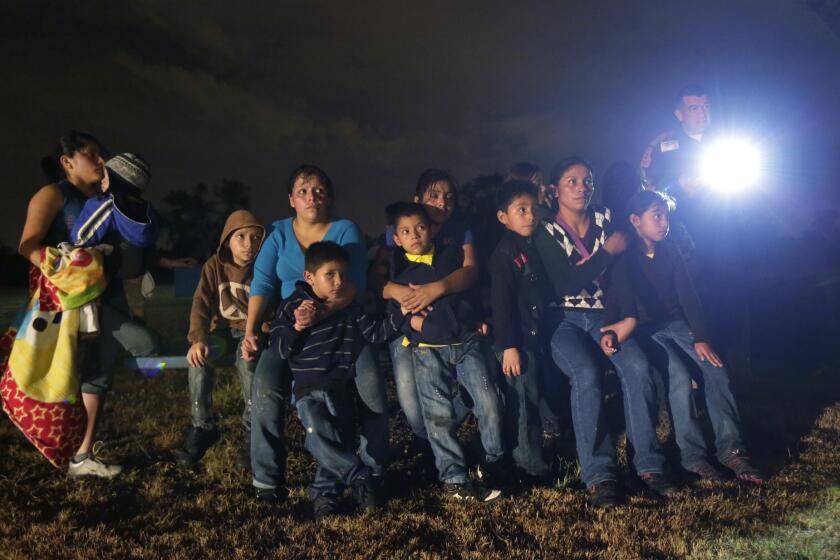 A group of immigrants from Honduras and El Salvador who crossed the U.S.-Mexico border illegally are stopped in Granjeno, Texas, in June.
